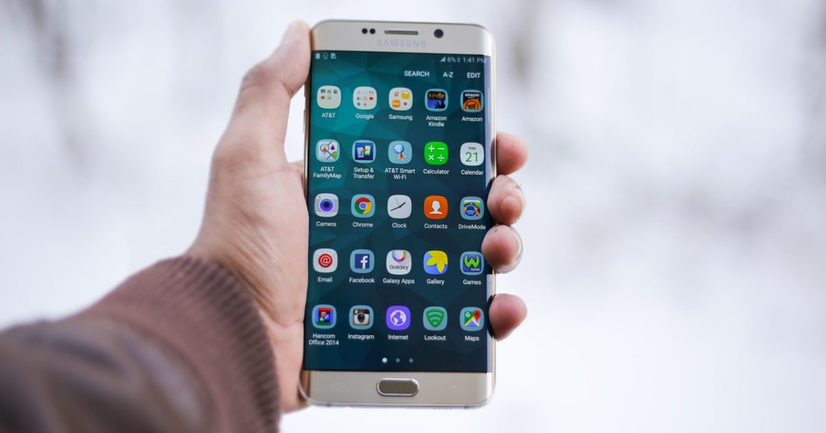 手机号码 App 主界面在浅色桌面上展示号段核对结果，屏幕中列出号码归属省份与运营商标签，旁边放着记事本与笔，光线明亮整洁